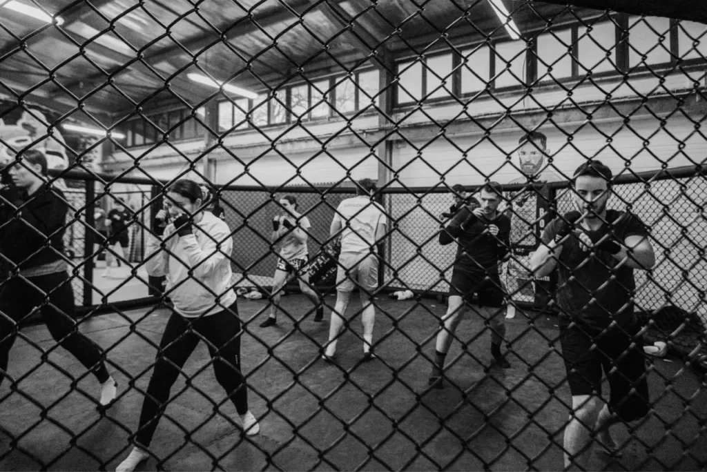 Une photo en noir et blanc montrant des adhérents du club de Ramonville en train de s'entraîner au MMA.