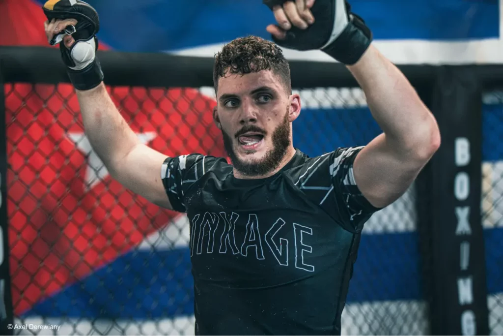 Un champion de boxe MMA lève les bars lors de sa victoire.